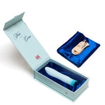 Open box of Singapore Blush Oh My Gem blue edition with a satin storage pouch and USB charging cable—perfect for gifting or self-love rituals with sleek, travel-friendly design.