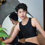 A non-binary person gazes into a mirror while wearing TOMSCOUT’s black binder, celebrating fluid identity and the freedom of self-expression with a modern, gender-inclusive wardrobe essential.