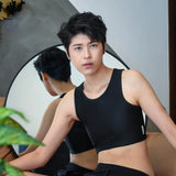 A non-binary person gazes into a mirror while wearing TOMSCOUT’s black binder, celebrating fluid identity and the freedom of self-expression with a modern, gender-inclusive wardrobe essential.