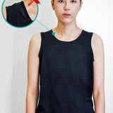 Non-binary model wearing a basic black tank top with a visible underarm seam bulge, highlighting common layering issues over traditional binders—emphasizing the need for TOMSCOUT’s ultra-smooth, low-profile chest binder solution.