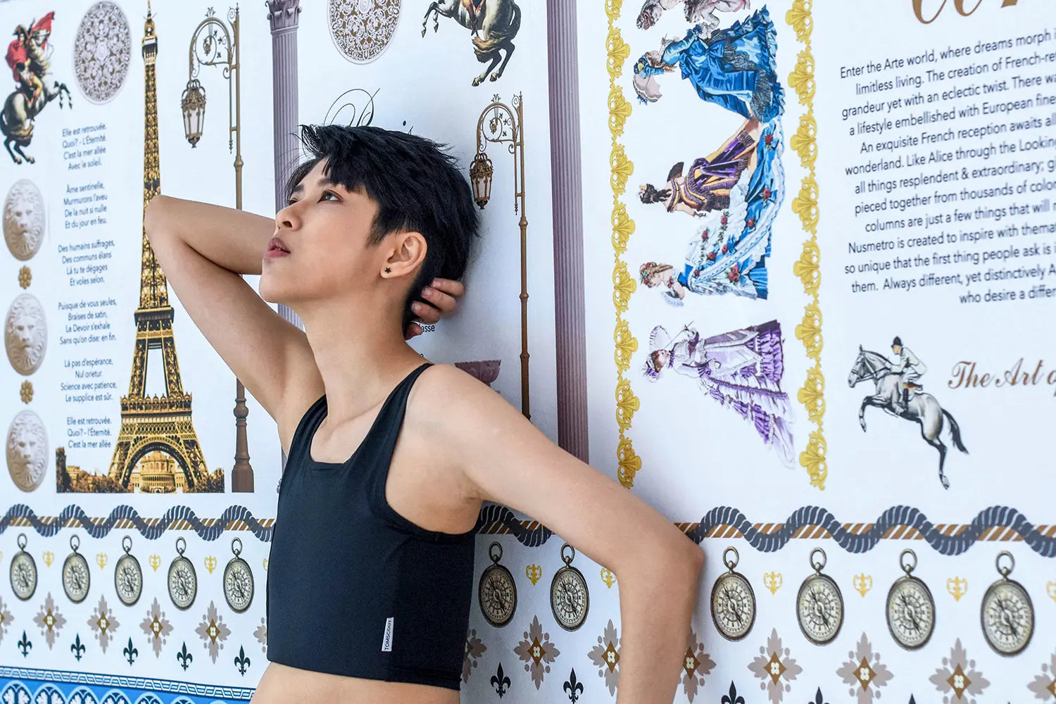 With eyes lifted toward a whimsical Parisian backdrop, a lesbian model poses in a TOMSCOUT chest binder that combines structure with softness—merging queer style with historical romance flair.