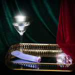 Singapore Blush Oh My Gem blue vibrator placed on a mirrored gold tray beside a martini glass and faux gems—luxuriously styled to reflect queer pleasure, solo indulgence, and aesthetic empowerment.