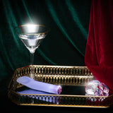 Singapore Blush Oh My Gem blue vibrator placed on a mirrored gold tray beside a martini glass and faux gems—luxuriously styled to reflect queer pleasure, solo indulgence, and aesthetic empowerment.