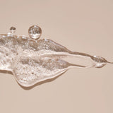 Close-up of glistening HARU lubricant with silky texture and visible bubbles, showcasing hydrating, body-safe ingredients that elevate intimate moments for all gender expressions.