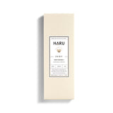 Minimalist cream-toned box of HARU Dewy water-based lubricant, featuring Ylang Ylang extract for silky, sensual intimacy—ideal for enhancing comfort and pleasure during queer and gender-affirming intimacy.