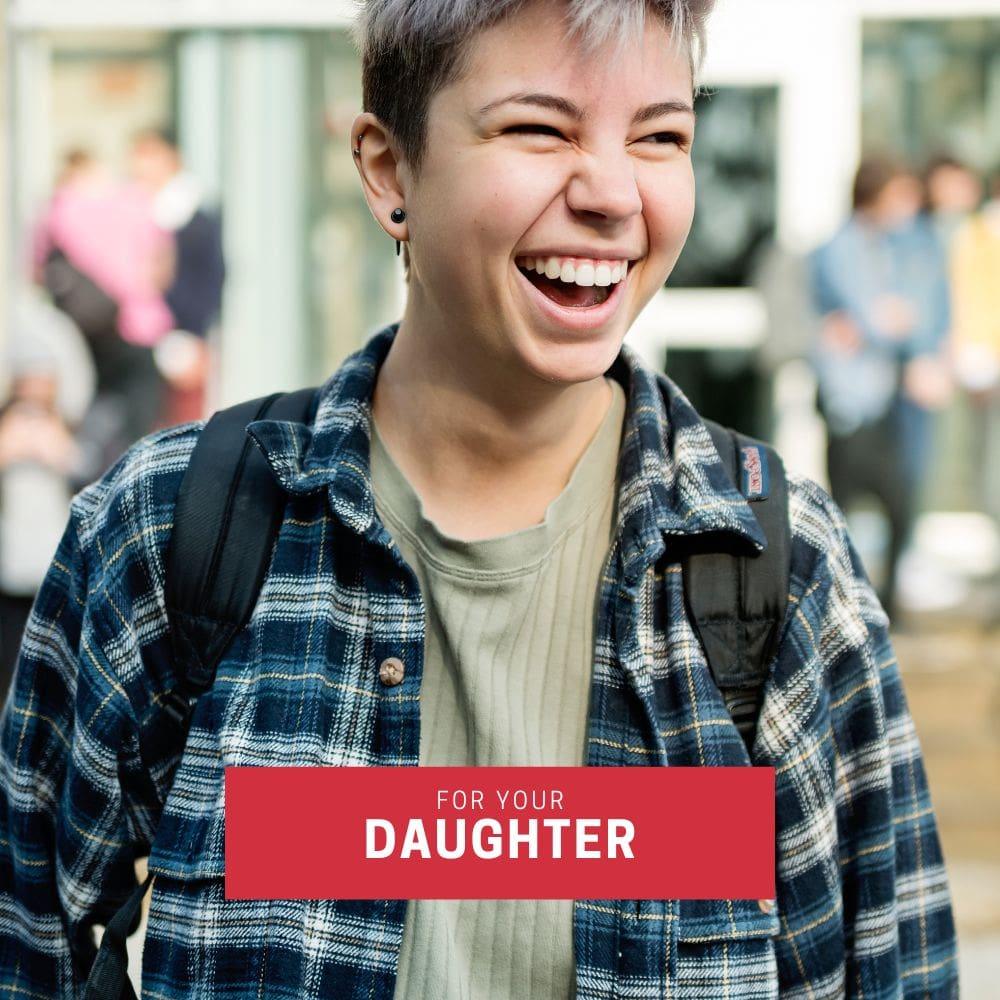 Youthful queer person in plaid flannel and cropped hair laughing joyfully, captioned “For Your Daughter”—a perfect visual for gifting a TOMSCOUT card to support their journey, style, or comfort needs.