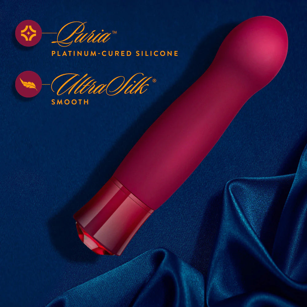 Singapore Blush Oh My Gem “Classy” vibe resting on rich blue satin fabric, emphasizing its smooth UltraSilk® silicone and elegant aesthetic—blending gender expression with luxe erotic empowerment.