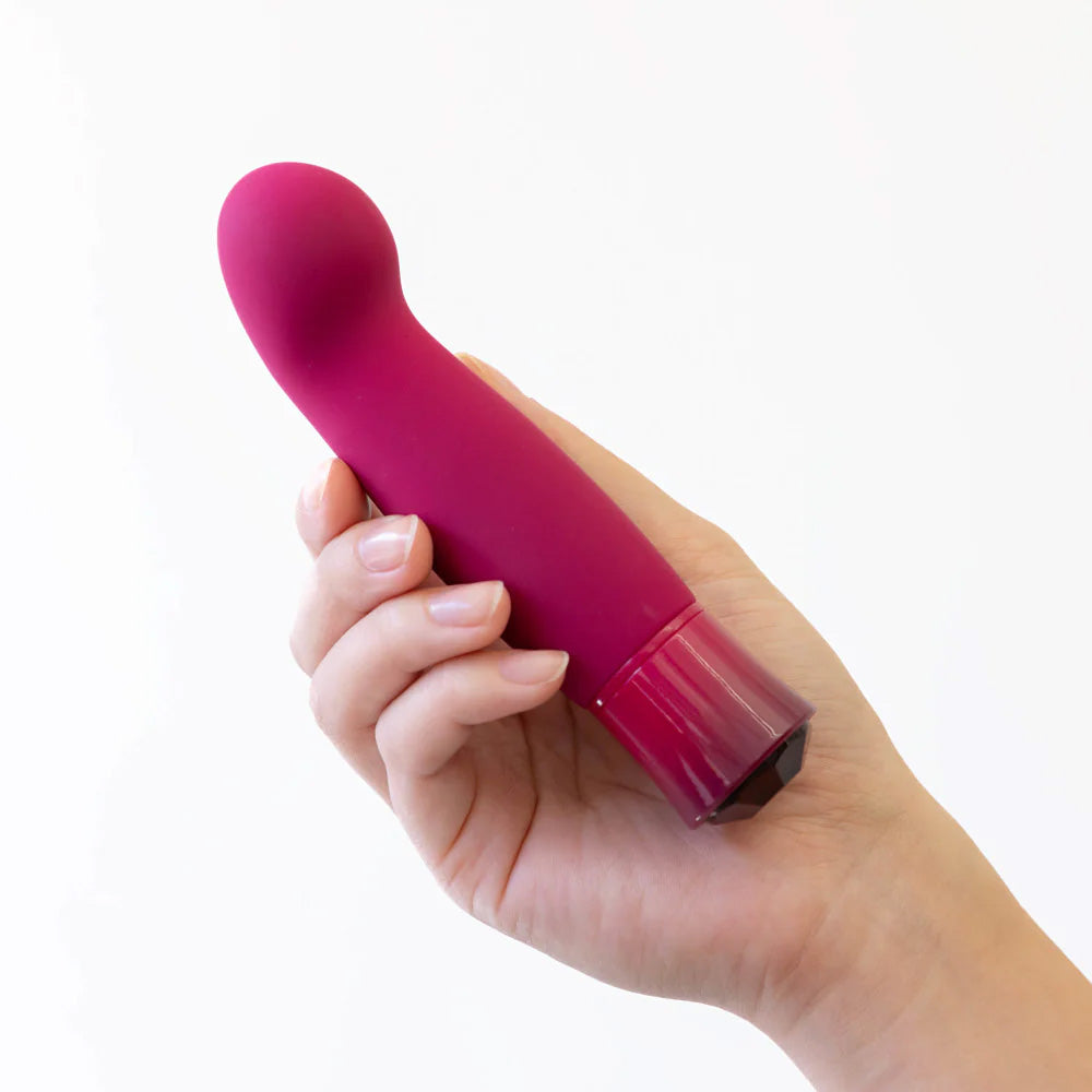 Close-up of a hand holding the burgundy Singapore Blush Oh My Gem vibe, showing its compact design and comfortable grip—perfect for androgynous users exploring G-spot discovery on their own terms.