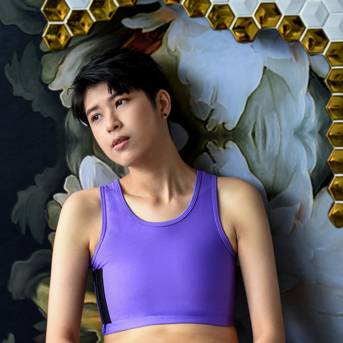 Non-binary androgynous tomboy transman lesbian wearing a TOMSCOUT lavender purple Chest Binder, embracing the triumph over body dysphoria and experiencing gender euphoria with a flattened chest. Featured in the TOMSCOUT Free Chest Binder Program, The Freedom Binder.