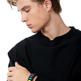 Stylish model elegantly wearing the TOMSCOUT LGBTQ+ Pride Paracord Bracelet with a striking rainbow design, a sustainable and fashionable accessory for expressing LGBTQ+ pride and solidarity.