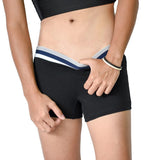 Close-up of a tomboy-presenting person adjusting the waistband of TOMSCOUT’s black boxer briefs. The snug athletic band offers stylish support without digging, designed for queer bodies craving gender euphoria and everyday ease.