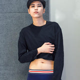 Androgynous model wearing navy boxer briefs with a red, white, and blue waistband, paired with a black crop top. The gender-neutral silhouette highlights TOMSCOUT’s inclusive underwear line—soft, stretchy, and built for comfort and dysphoria-safe style.
