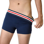 Close-up of a non-binary person adjusting navy TOMSCOUT boxer briefs, showcasing the elastic waistband and body-hugging fit. Designed for all-day movement, comfort, and a gender-affirming alternative to traditional underwear.
