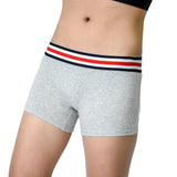FTM-presenting individual in TOMSCOUT heather grey boxer briefs with signature tricolor waistband. Breathable cotton blend offers a secure fit that supports trans masc comfort, visibility, and body neutrality.