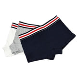 Flat lay of TOMSCOUT’s gender-inclusive boxer briefs in white, grey, and navy. Featuring signature athletic waistband and stretch-cotton blend—perfect for tomboys, trans men, and non-binary wearers looking for everyday confidence and support.