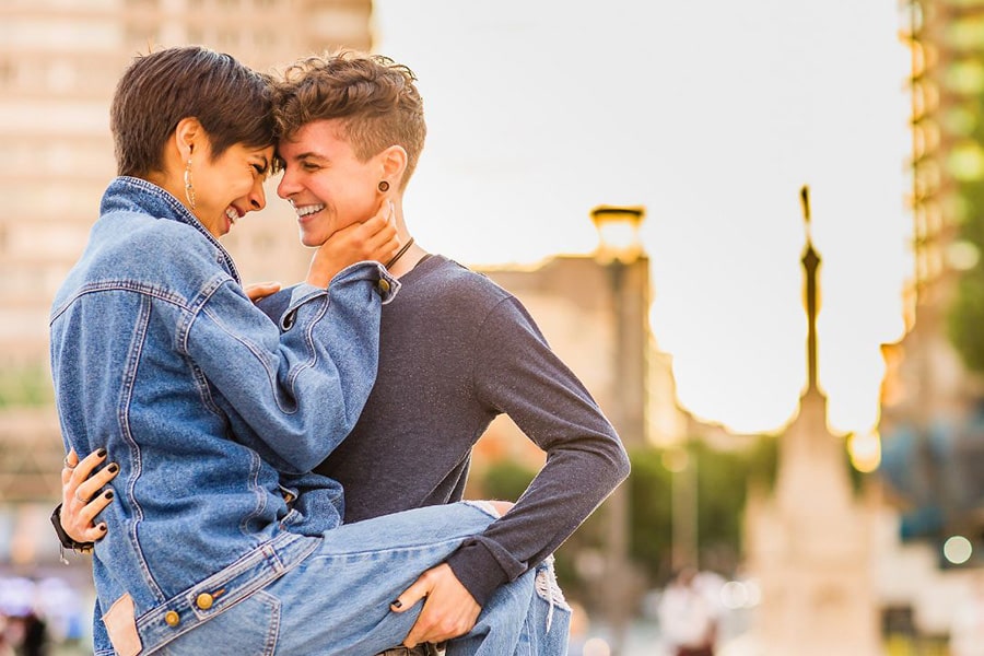 Joyful lesbian couple in a heartwarming photoshoot, radiating laughter and love, symbolizing the beauty of their relationship.