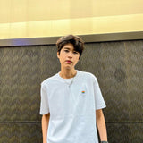 Tomboy androgynous transgender model donning a high-quality, embroidered white t-shirt with a pride flag design from the TOMSCOUT Pride clothing collection. The shirt's simple yet classic style, sustainable craftsmanship, and sophisticated appearance showcase LGBT-friendly fashion at its finest.