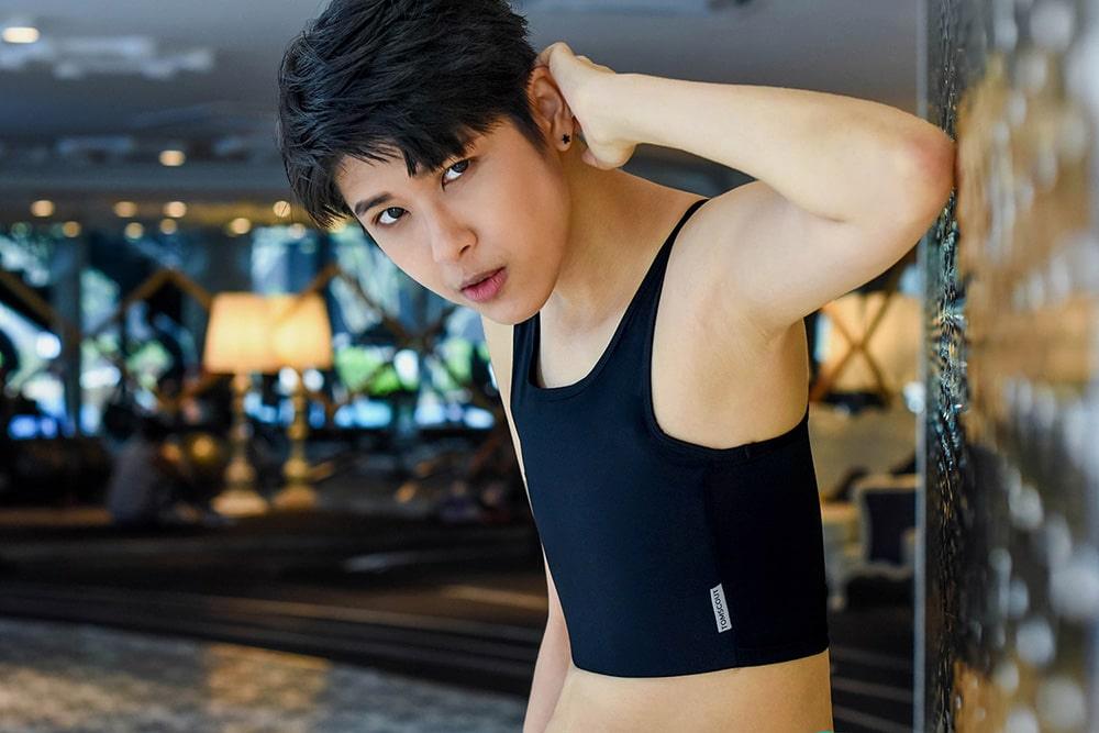 Sustainable and high-quality TOMSCOUT 20cm chest binder worn by a non-binary androgynous tomboy and transgender man, showcasing durability while combating body dysphoria. Exercising with the durable TOMSCOUT STRENGTH bandage binder.
