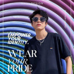 Tomboy androgynous transgender model donning a high-quality, embroidered black t-shirt with a pride flag design from the TOMSCOUT Pride clothing collection. The shirt's simple yet classic style, sustainable craftsmanship, and sophisticated appearance showcase LGBT-friendly fashion at its finest.
