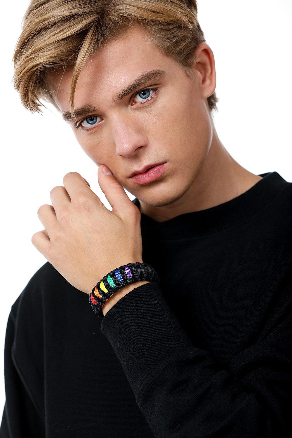 Stylish model elegantly wearing the TOMSCOUT LGBTQ+ Pride Paracord Bracelet with a striking rainbow design, a sustainable and fashionable accessory for expressing LGBTQ+ pride and solidarity.