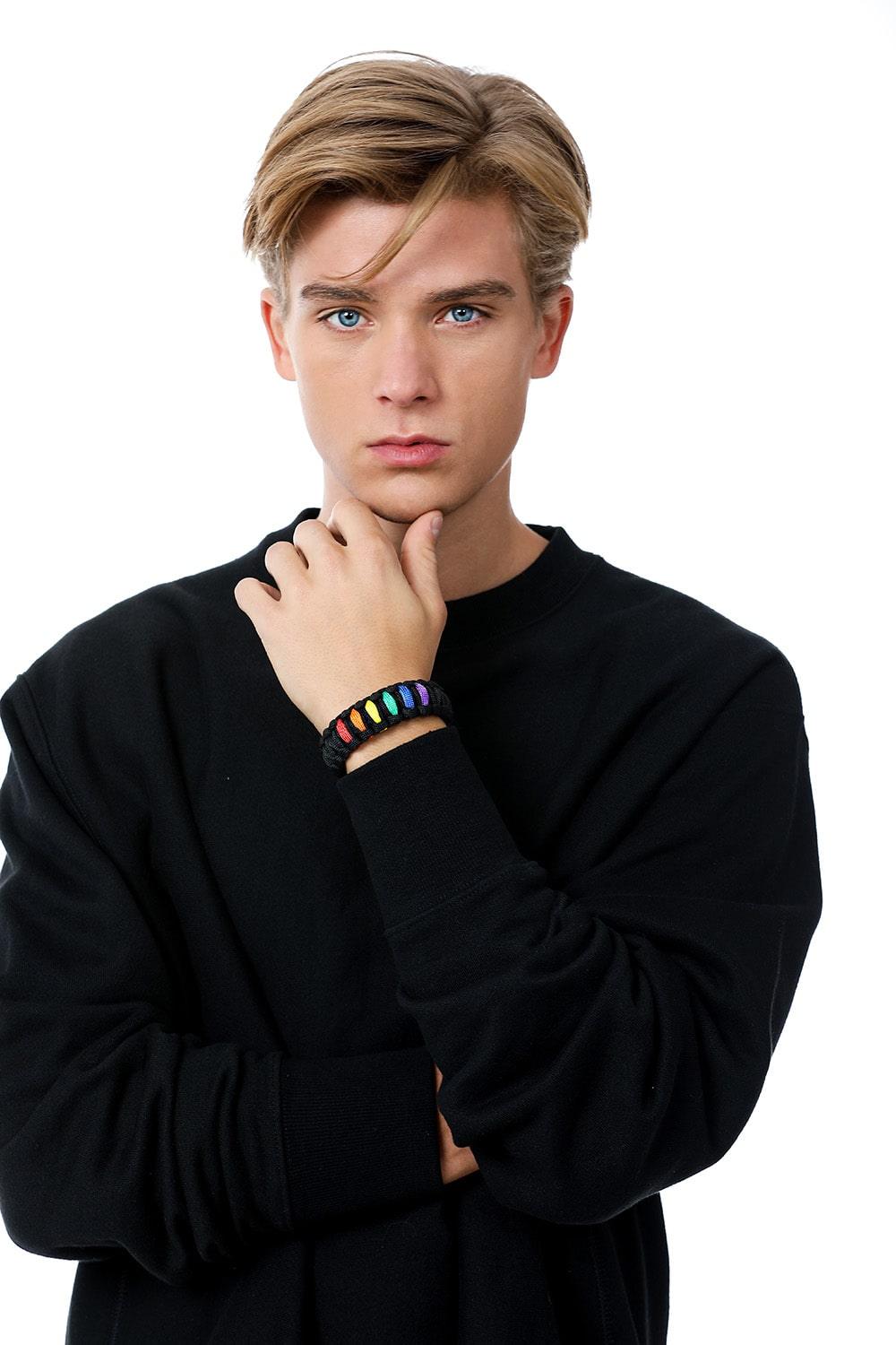 Stylish model elegantly wearing the TOMSCOUT LGBTQ+ Pride Paracord Bracelet with a striking rainbow design, a sustainable and fashionable accessory for expressing LGBTQ+ pride and solidarity.