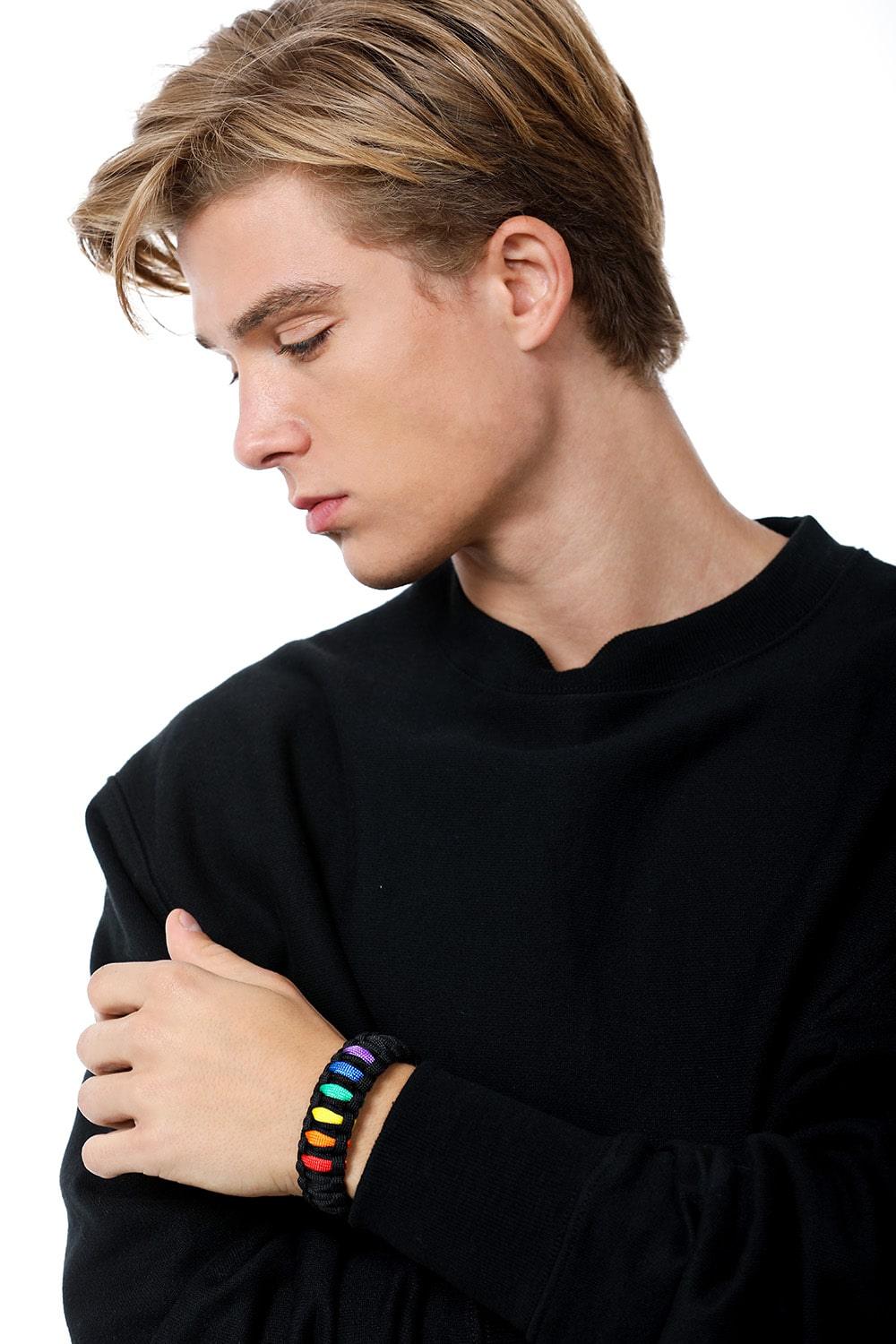 Stylish model elegantly wearing the TOMSCOUT LGBTQ+ Pride Paracord Bracelet with a striking rainbow design, a sustainable and fashionable accessory for expressing LGBTQ+ pride and solidarity.