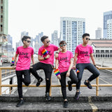 Dynamic group of Asian tomboys clad in hot pink t-shirts with 'Love Wins' front print, each holding a pride flag. Join the movement with TOMSCOUT Flourish - LGBT Pride Kits, a symbol of unity and pride in Singapore.
