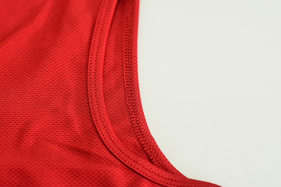 Close-up view of the 'Freedom Binder', a product from TOMSCOUT's free chest binder program, in a vibrant scarlet red color. This image highlights the product details, showcasing its high quality, sustainability, and durability, reflecting TOMSCOUT's commitment to providing supportive and long-lasting solutions for the LGBT community in Singapore.