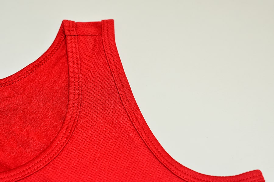 Close-up view of the 'Freedom Binder', a product from TOMSCOUT's free chest binder program, in a vibrant scarlet red color. This image highlights the product details, showcasing its high quality, sustainability, and durability, reflecting TOMSCOUT's commitment to providing supportive and long-lasting solutions for the LGBT community in Singapore.