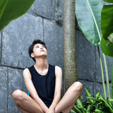 A non-binary androgynous tomboy, transgender man wearing a black color of a bandage TOMSCOUT Swimming Chest Binder to fight body dysphoria and swimming in the pool, TOMSCOUT SAPPHIRE SWIMMING BINDER.