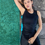 A non-binary androgynous tomboy, transgender man wearing a black color of a bandage TOMSCOUT Swimming Chest Binder to fight body dysphoria and swimming in the pool, TOMSCOUT SAPPHIRE SWIMMING BINDER.