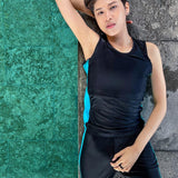 A non-binary androgynous tomboy, transgender man wearing a black color of a bandage TOMSCOUT Swimming Chest Binder to fight body dysphoria and swimming in the pool, TOMSCOUT SAPPHIRE SWIMMING BINDER.