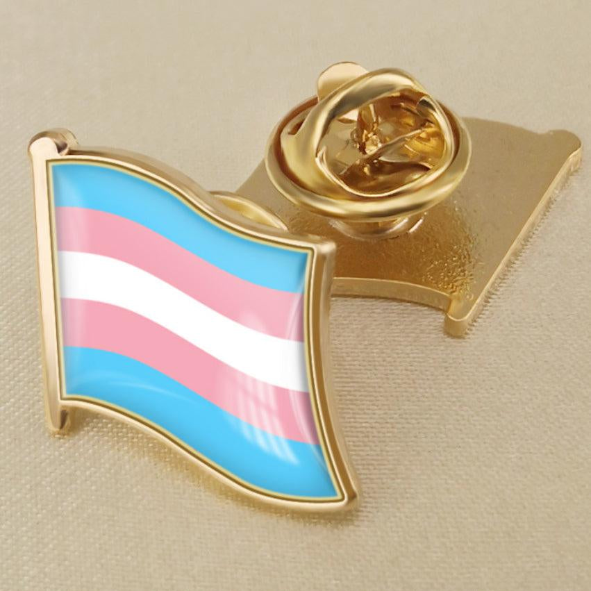 Product listing image of a TOMSCOUT LGBTQ+ Pride Transgender Metal Badge, pinned on a shirt, showcasing a symbol of pride and identity.