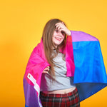 A bisexual young girl smiling and holding with a LGBTQ Bisexual Pride Flag. TOMSCOUT LGBTQ+ Bisexual Flag