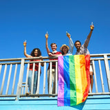 A group of friends are cheering with a LGBTQ Rainbow Pride Flag. TOMSCOUT LGBTQ+ Classic Pride Flag